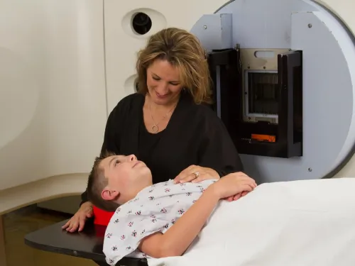 A mum sitting talking to her child while he waits for a scan.